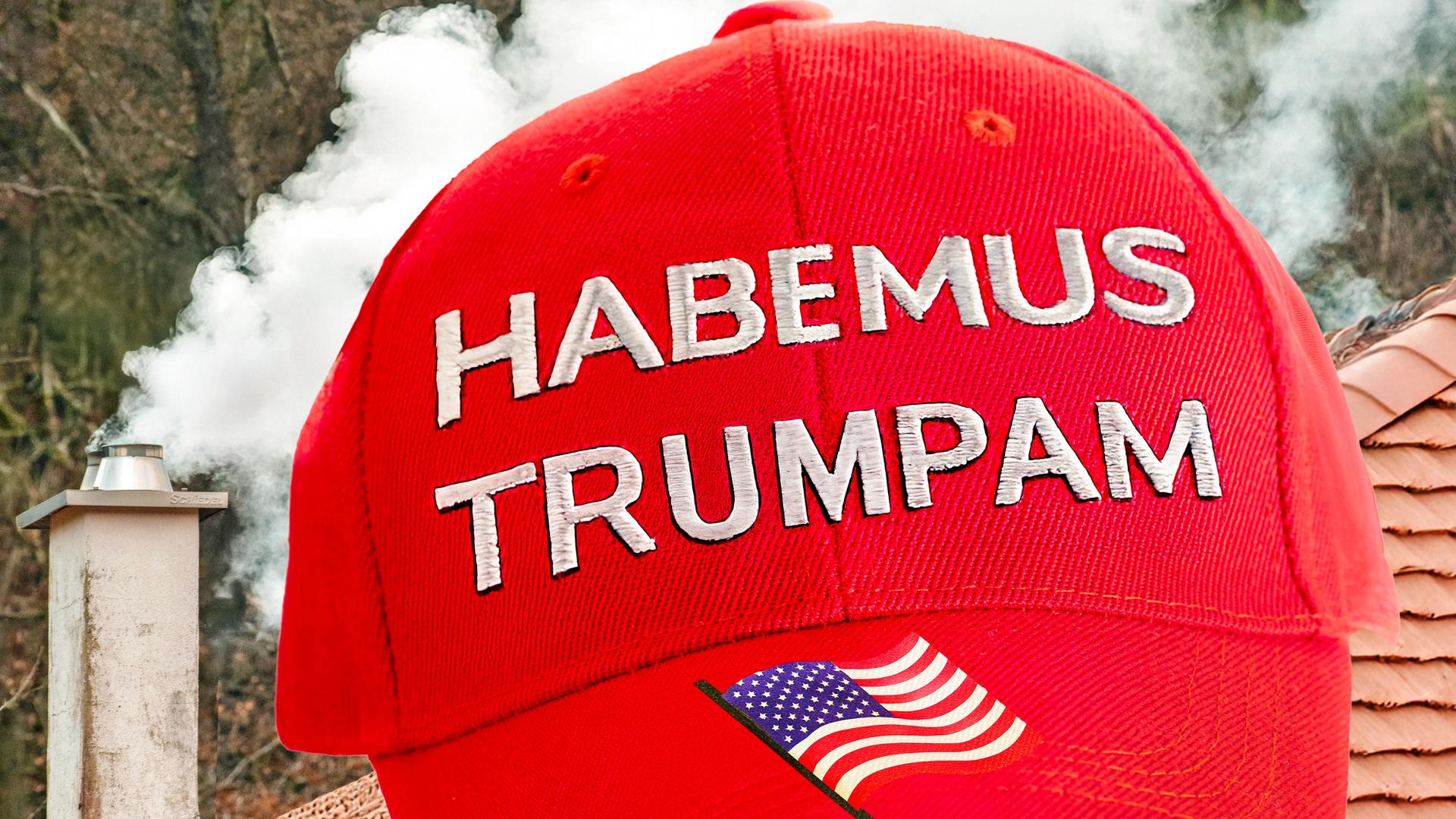 Eine rote Baseball-Mütze mit der weißen Schrift "Habemus Trumpam" und eine US-amerikanische Flagge, weißer Rauch steigt symbolisch aus einem Schornstein auf