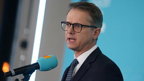 Carsten Linnemann spricht in ein Mikrofon mit CDU-Logo. 