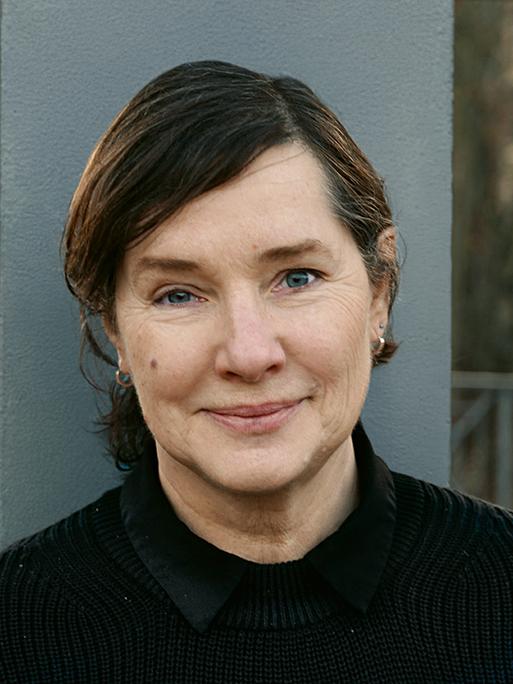 Porträtfoto von Annette Schuhmann vor einem Stahlträger.            