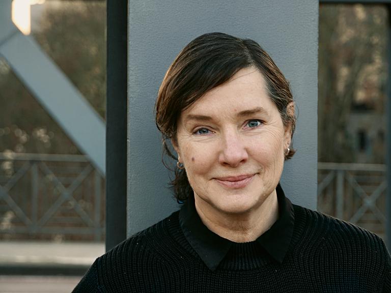 Porträtfoto von Annette Schuhmann vor einem Stahlträger.            