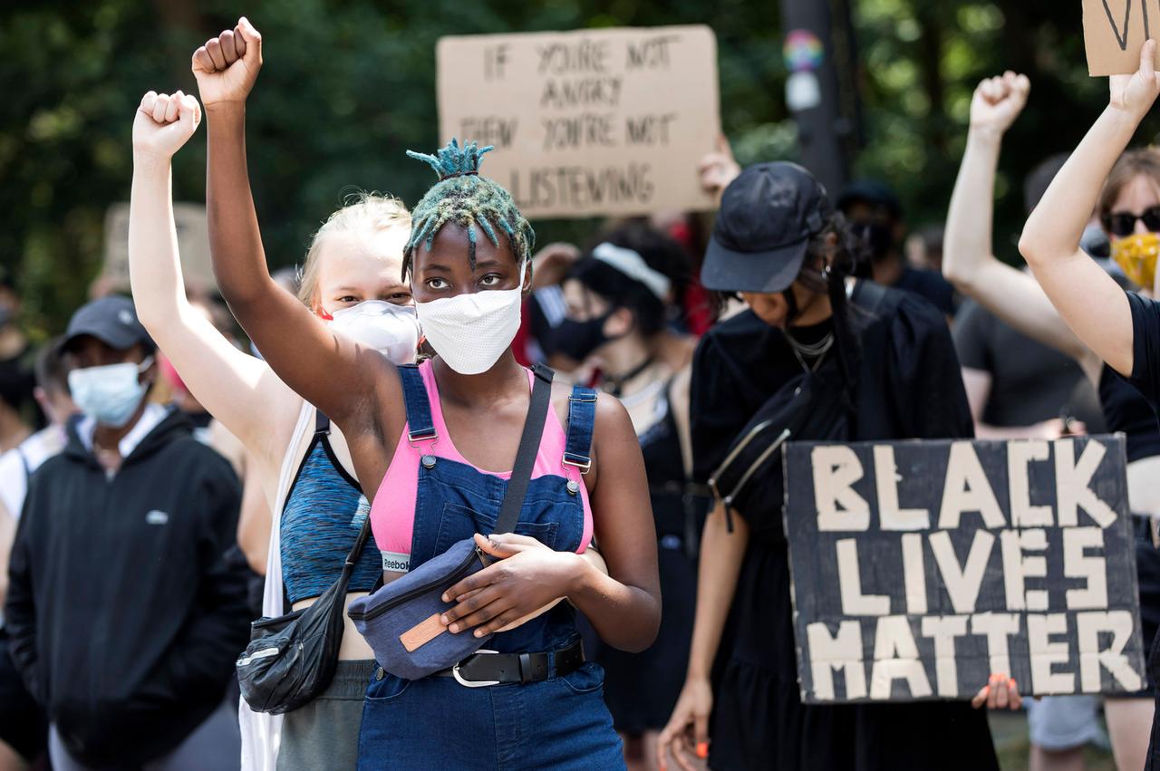 Zwei junge Frauen heben ihre Hände auf der Black Lives Matter Demonstration gegen Rassismus auf der Strasse des 17. Juni. Berlin, 27.06.2020.