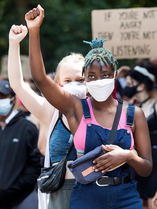 Zwei junge Frauen heben ihre Hände auf der Black Lives Matter Demonstration gegen Rassismus auf der Strasse des 17. Juni. Berlin, 27.06.2020.