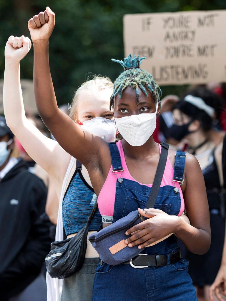 Zwei junge Frauen heben ihre Hände auf der Black Lives Matter Demonstration gegen Rassismus auf der Strasse des 17. Juni. Berlin, 27.06.2020.