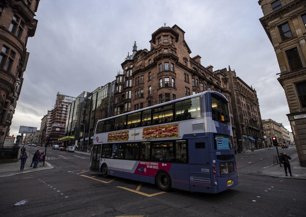 Ein Bus fährt durch eine Straße von Glasgow
