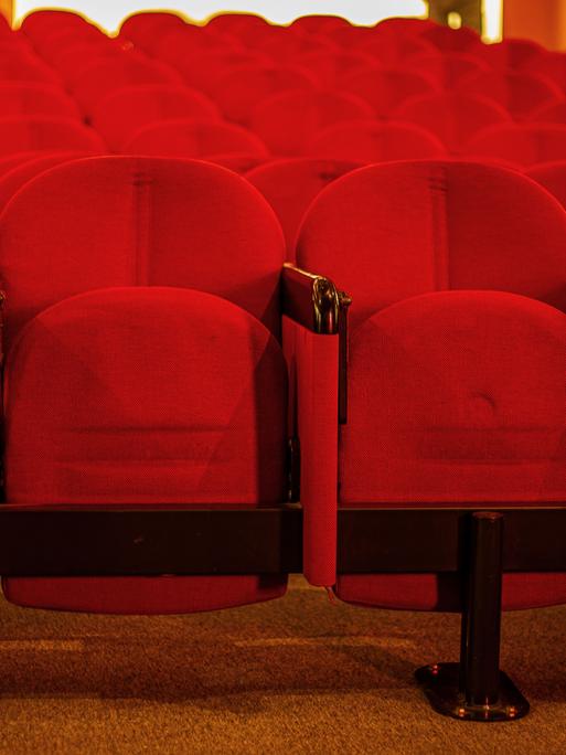 Mehrere leere Reihen Kinosessel in einem Kino. Mehrere leere Reihen Kinosessel in einem Kino.