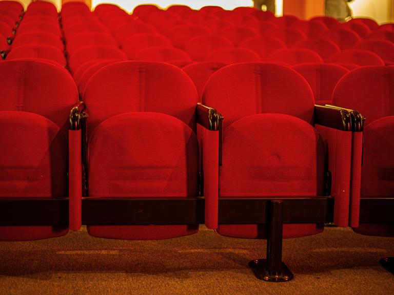 Mehrere leere Reihen Kinosessel in einem Kino. Mehrere leere Reihen Kinosessel in einem Kino.