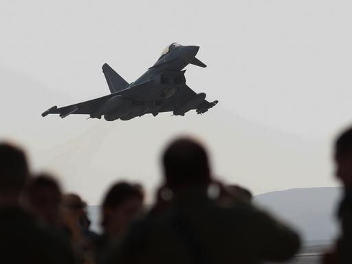 Ein Kampfjet vom Typ Eurofighter Typhoon startet, im Bildvordergrund sind Zuschauer zu sehen.