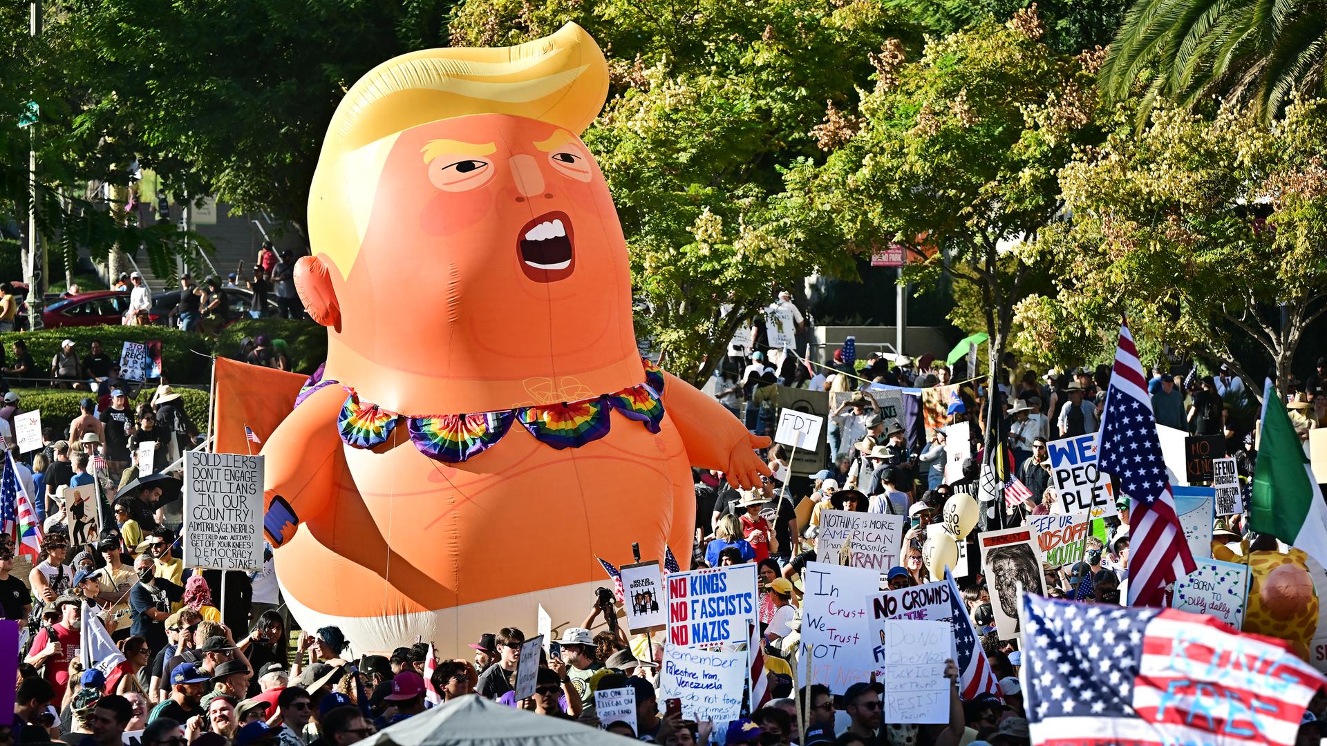 Eine No-Kings-Demonstration mit Plakaten und einer großen aufblasbaren Puppe in Form von Donald Trump