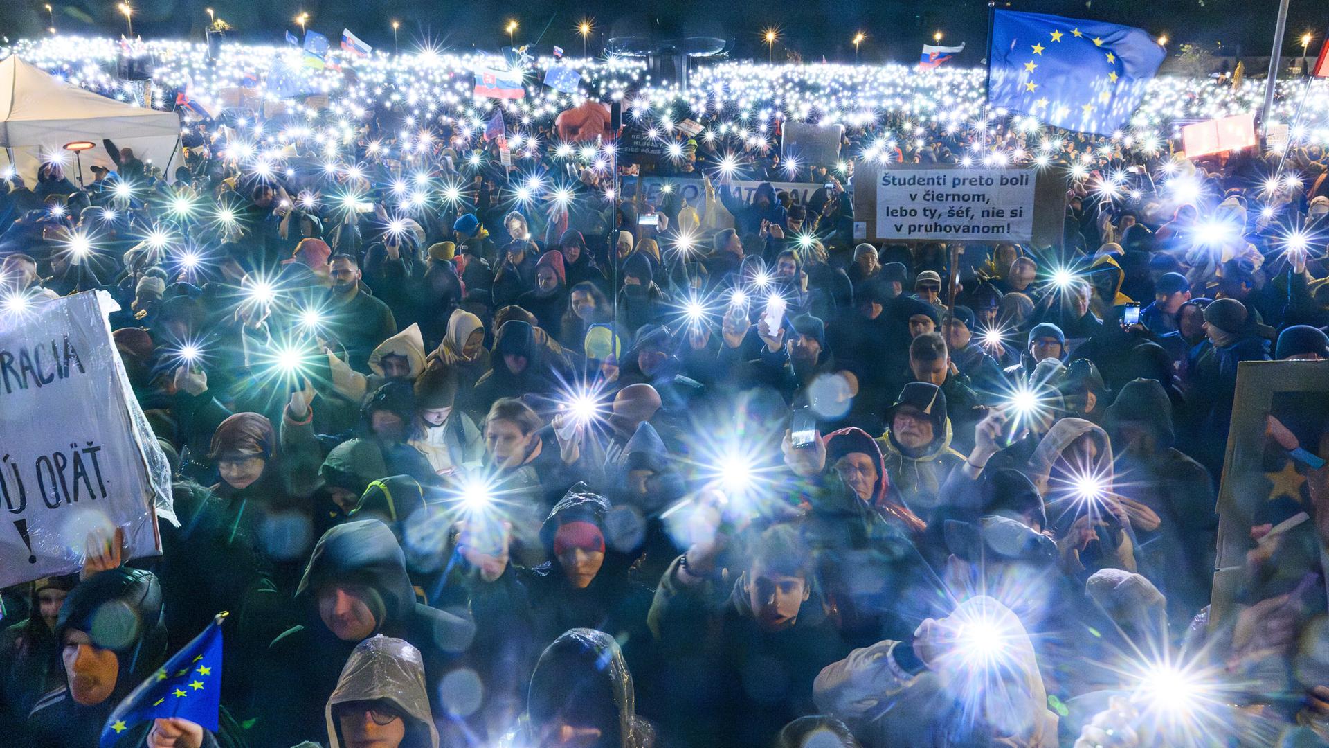 Tausende Menschen halten ihre leuchtenden Mobiltelefone hoch, die eine Art Sternenmeer über ihren Köpfen bilden. Tausende Menschen halten ihre leuchtenden Mobiltelefone hoch, die eine Art Sternenmeer über ihren Köpfen bilden.
