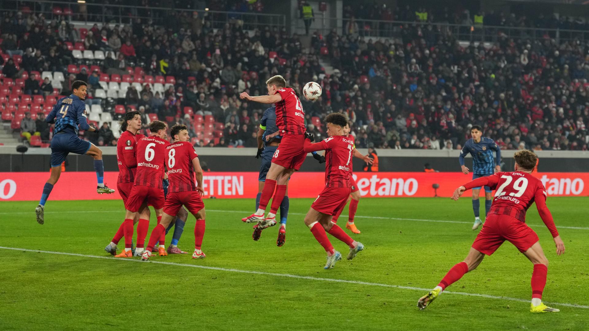 Fußballspieler vom SC Freiburg und Maccabi Tel Aviv kämpfen um den Ball. 