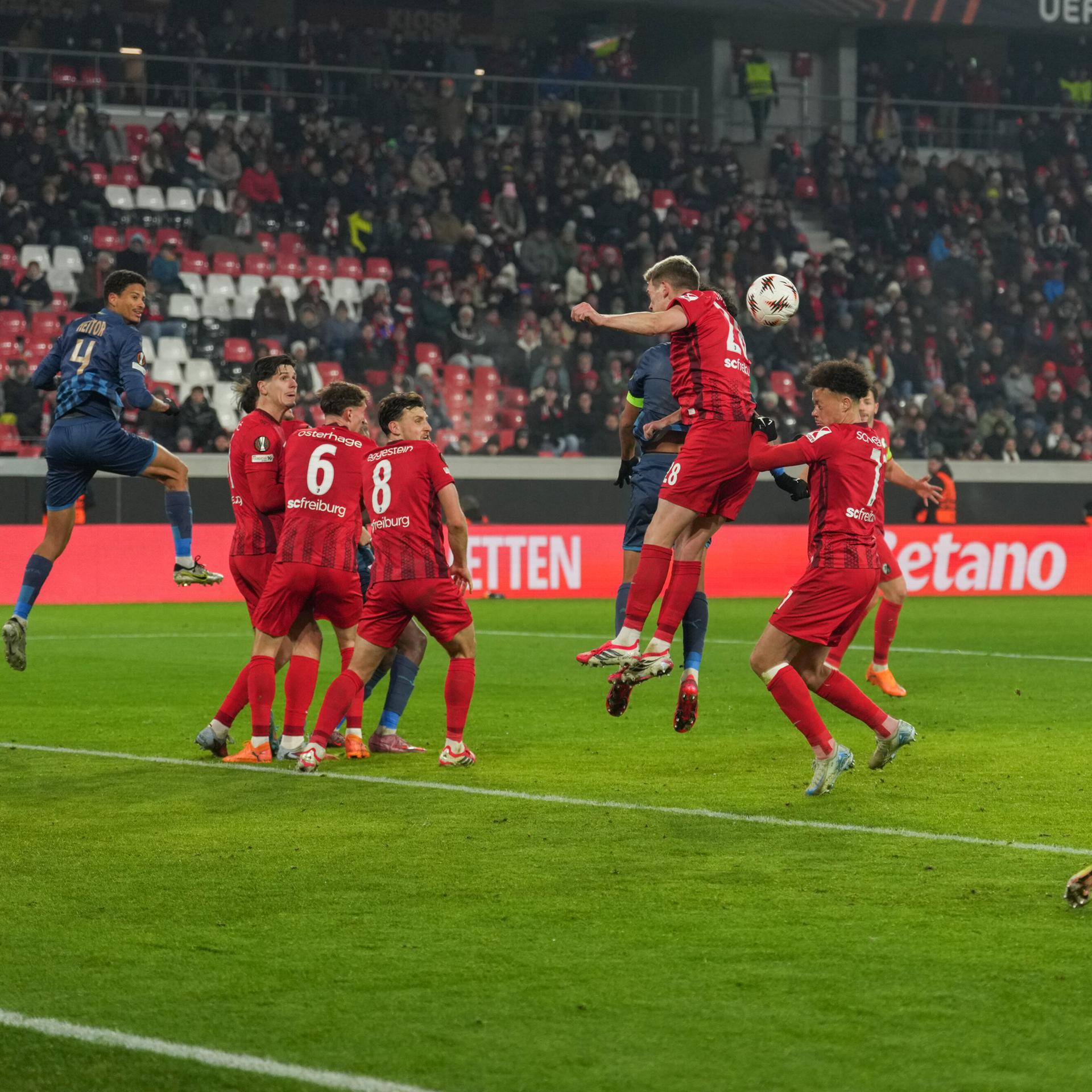 Fußballspieler vom SC Freiburg und Maccabi Tel Aviv kämpfen um den Ball. 