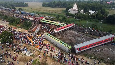 Das Foto zeigt viele Menschen am Ort eines schweren Zugunglücks. Man sieht auch viele umgestürzte Waggons.