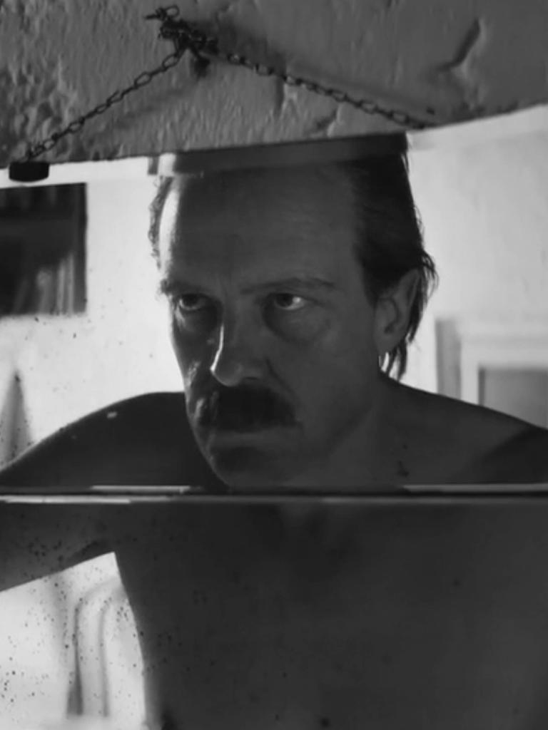 Schauspieler August Diehl schaut in der Figur des Josef Mengele in einer Filmszene in einen Spiegel und betrachtet sein Gesicht. 