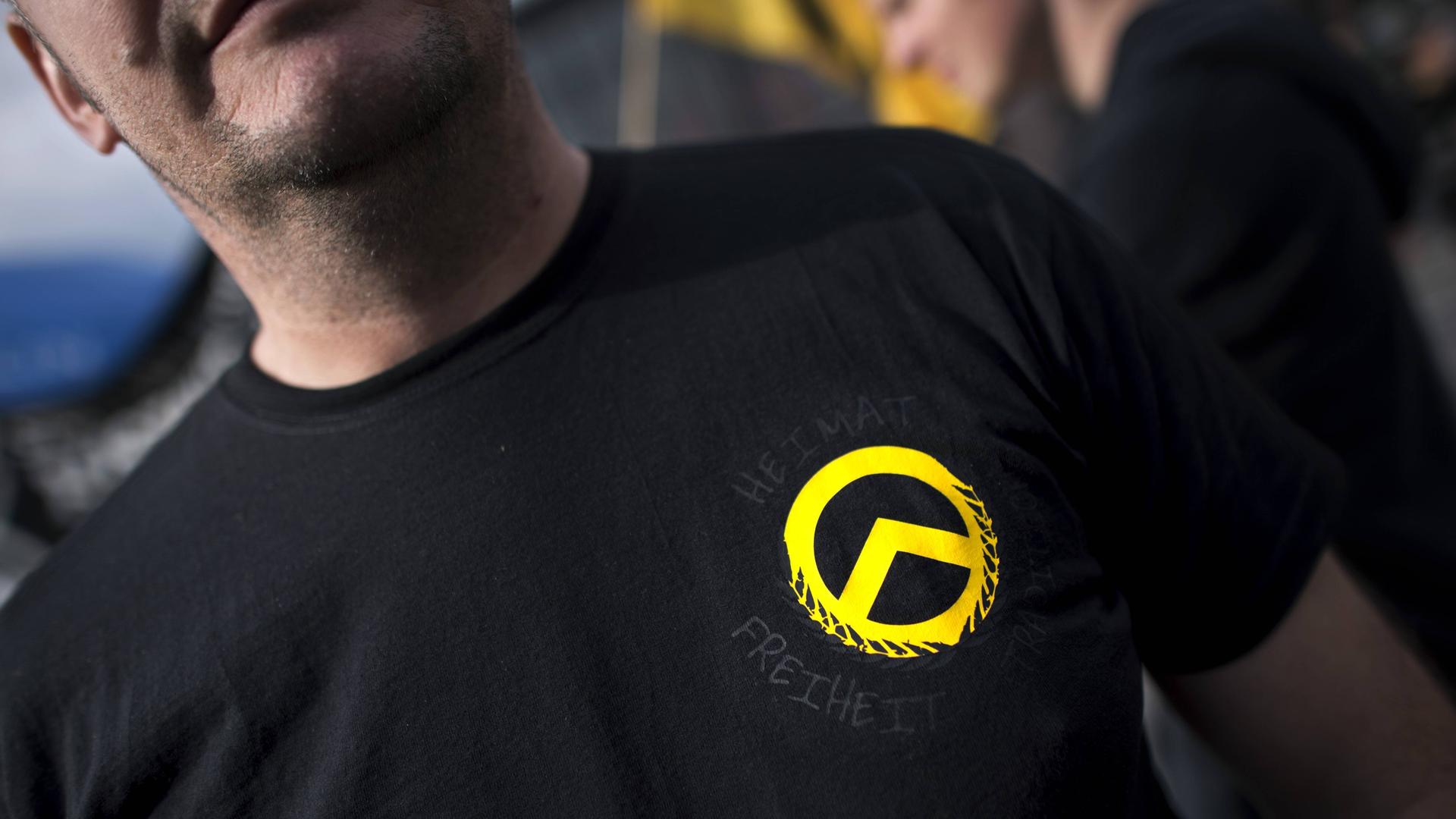 Ein Demonstrant mit dem gelben Logo der Identitären Bewegung auf einem schwarzen T-Shirt bei einer Demonstration der rechtsextremen Jugendbewegung.