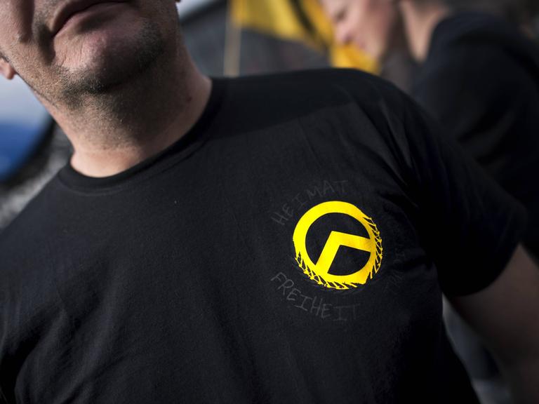 Ein Demonstrant mit dem gelben Logo der Identitären Bewegung auf einem schwarzen T-Shirt bei einer Demonstration der rechtsextremen Jugendbewegung.
