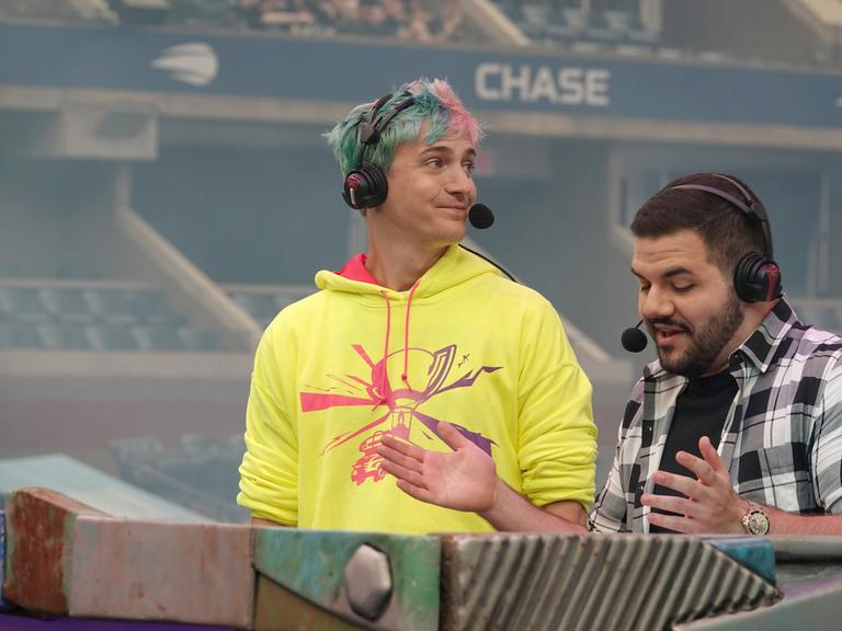 Tyler «Ninja» Blevins (l), einer der bekanntesten Streamer der Welt mit Millionen Followern auf der Plattform Twitch, steht beim Fortnite World Cup auf der Bühne. Bei dem Weltcup kämpfen knapp 200 junge Menschen um Preisgelder von 30 Millionen Dollar. Tyler «Ninja» Blevins (l), einer der bekanntesten Streamer der Welt mit Millionen Followern auf der Plattform Twitch, steht beim Fortnite World Cup auf der Bühne. Bei dem Weltcup kämpfen knapp 200 junge Menschen um Preisgelder von 30 Millionen Dollar.