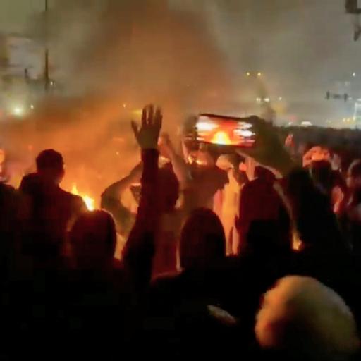 Dieser Ausschnitt aus Aufnahmen, die in den sozialen Medien kursieren, zeigt Demonstranten, die im iranischen Teheran um ein Feuer herum tanzen und jubeln.