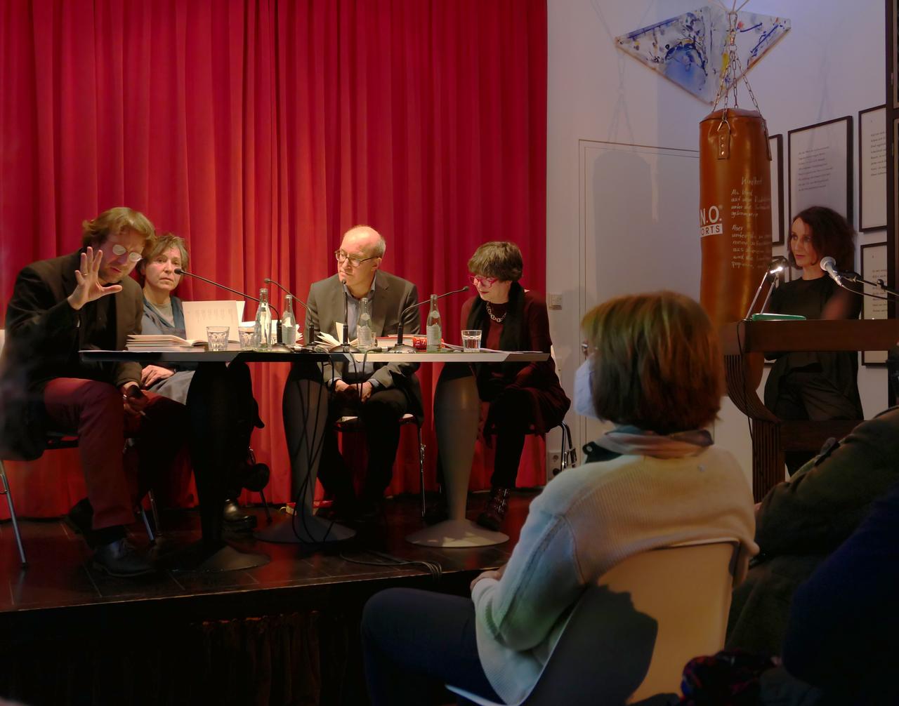 Auf einer Bühne sitzen Frieder von Ammon, Elke Schmitter, Jan Bürger und Barbara Wahlster gemeinsam am Tisch, rechts davon steht Birgitta Assheuer hinter einem Podium.