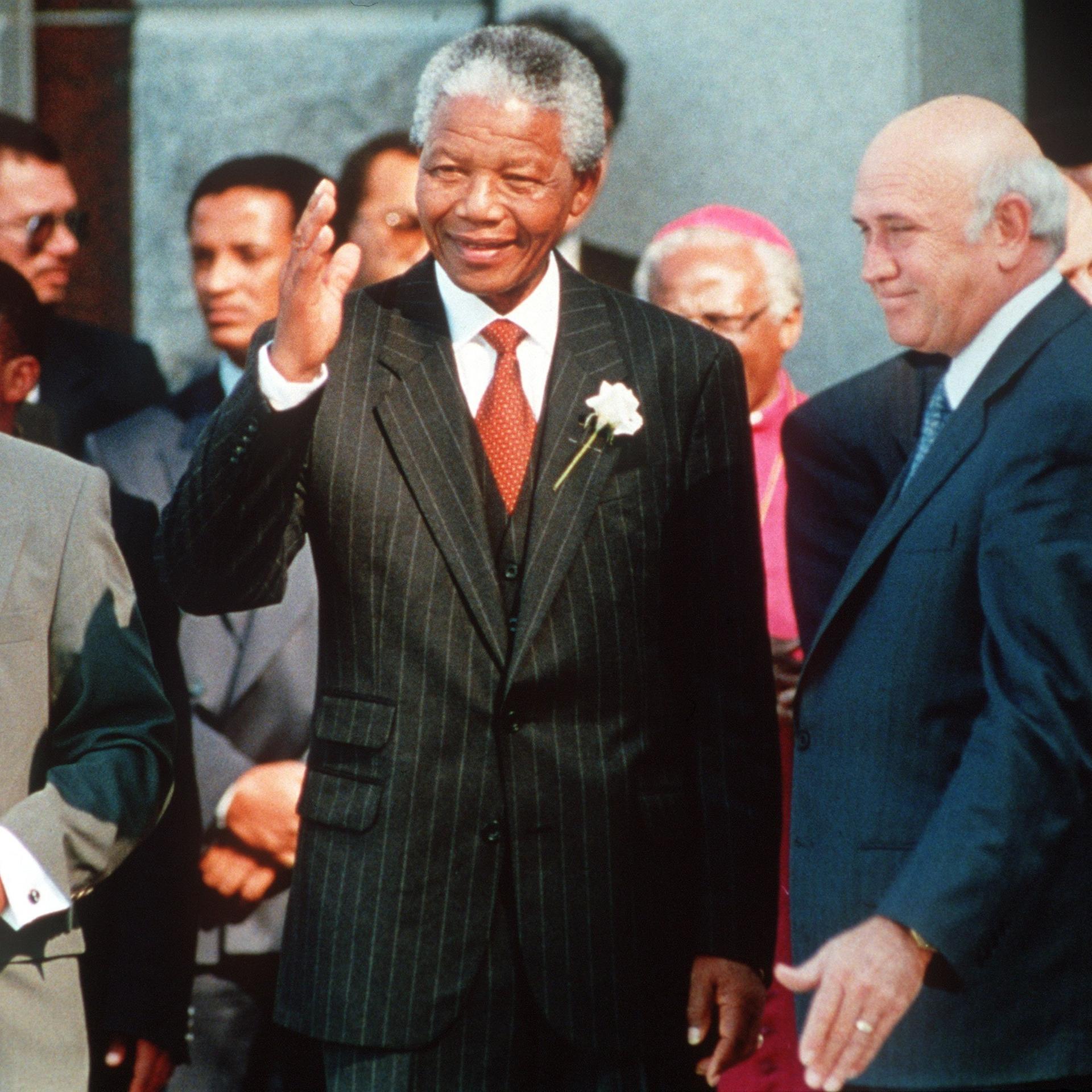 Am Vortag seiner Vereidigung winkt Südafrikas neuer Präsident Nelson Mandela (M), flankiert von seinen Stellvertretern Thabo Mbeki (l) und Ex-Präsident Frederik de Klerk, am 9. Mai 1994 Journalisten zu (Archivbild). Vor einem Jahrzehnt, am 1. Februar 1991, war die Apartheid in Südafrika 