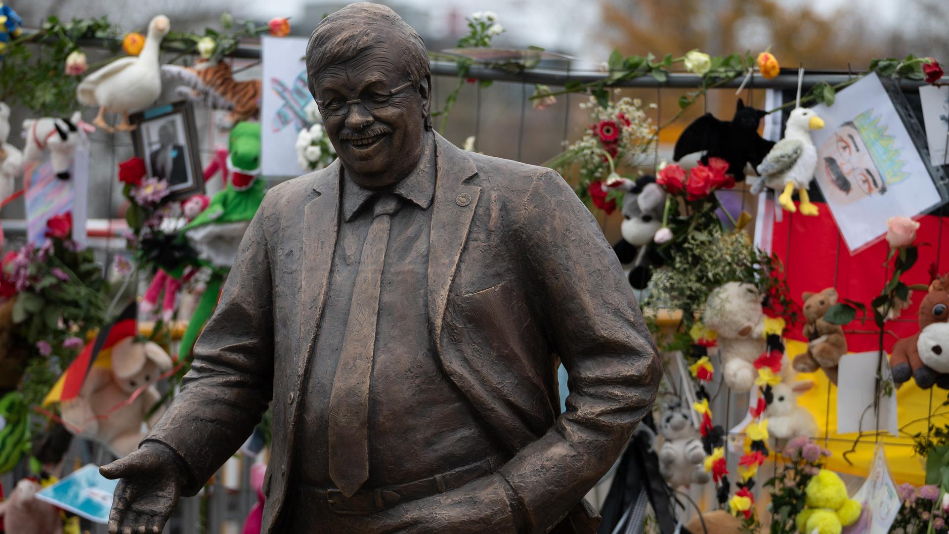 Eine lebensgroße Statue des ermordeten CDU-Politikers Walter Lübcke steht vor der CDU-Parteizentrale in Berlin. Ein Bauzaun dahinter ist mit Blumen und Bildern geschmückt.