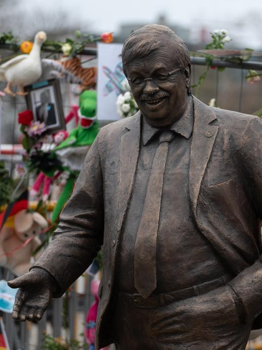 Eine lebensgroße Statue des ermordeten CDU-Politikers Walter Lübcke steht vor der CDU-Parteizentrale in Berlin. Ein Bauzaun dahinter ist mit Blumen und Bildern geschmückt.