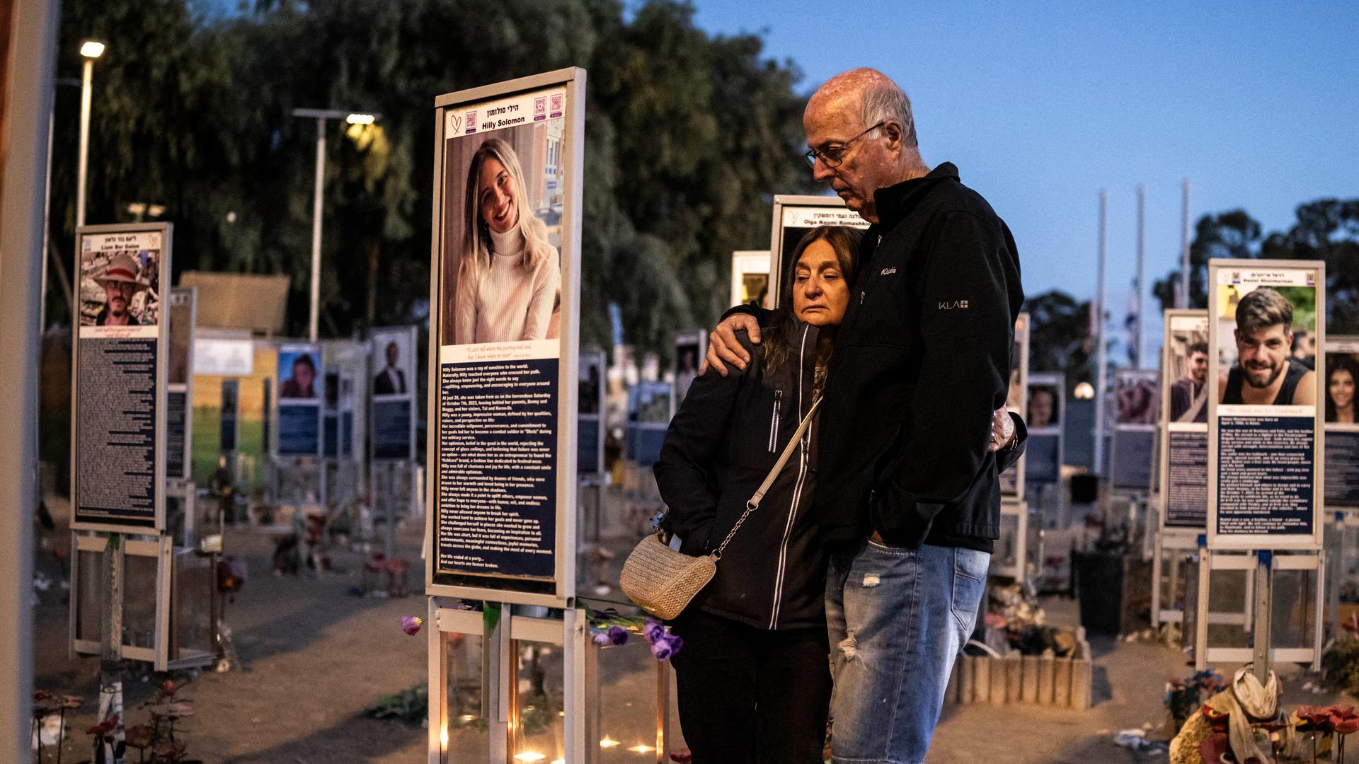 Zwei Menschen stehen vor einer Gedenktafel mit dem Bild einer jungen Frau. Zwei Menschen stehen vor einer Gedenktafel mit dem Bild einer jungen Frau.
