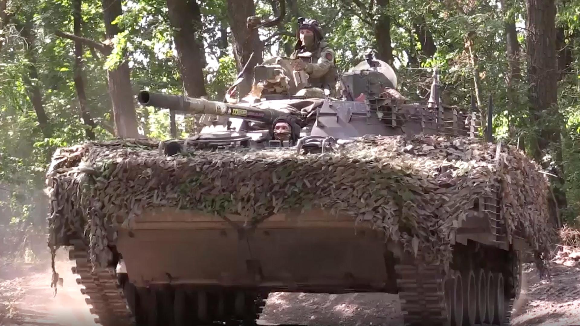 Dieses vom russischen Verteidigungsministerium freigegebene Bild zeigt zwei Soldaten in einem getarnten Panzer in der Region Donezk.