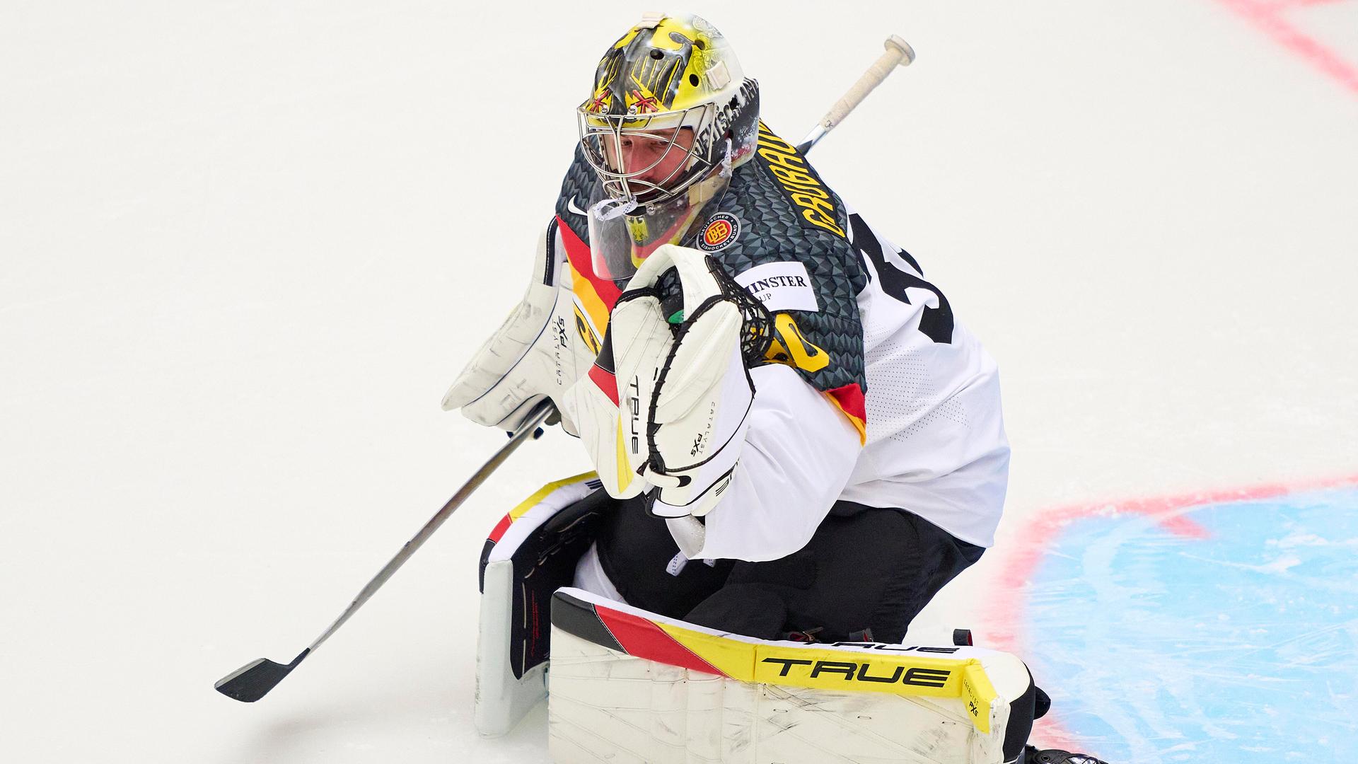 Philipp Grubauer kniet auf dem Eis. Er trägt das Trikot der deutschen Eishockey-Nationalmannschaft.