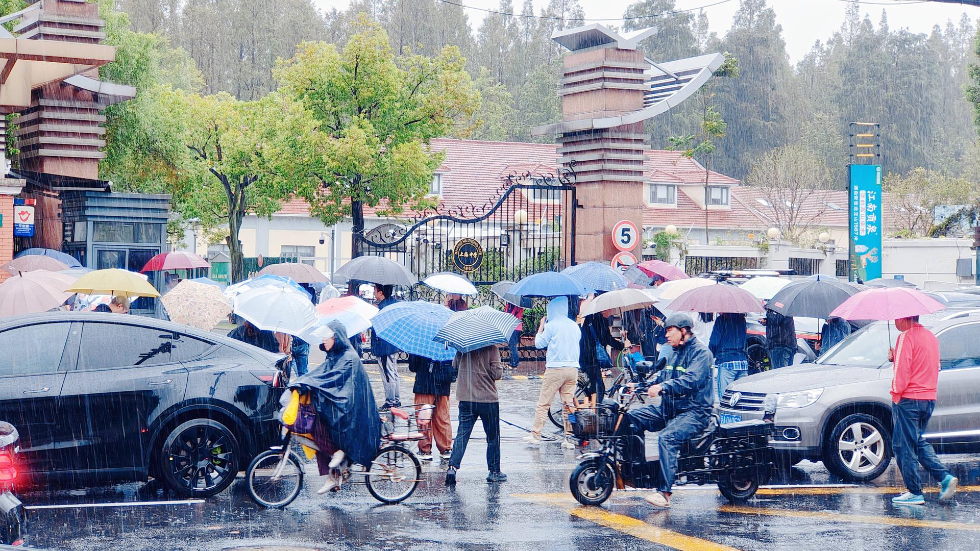 Eltern halten Regenschirme, um ihre Kinder von der Schule in Shanghai abzuholen