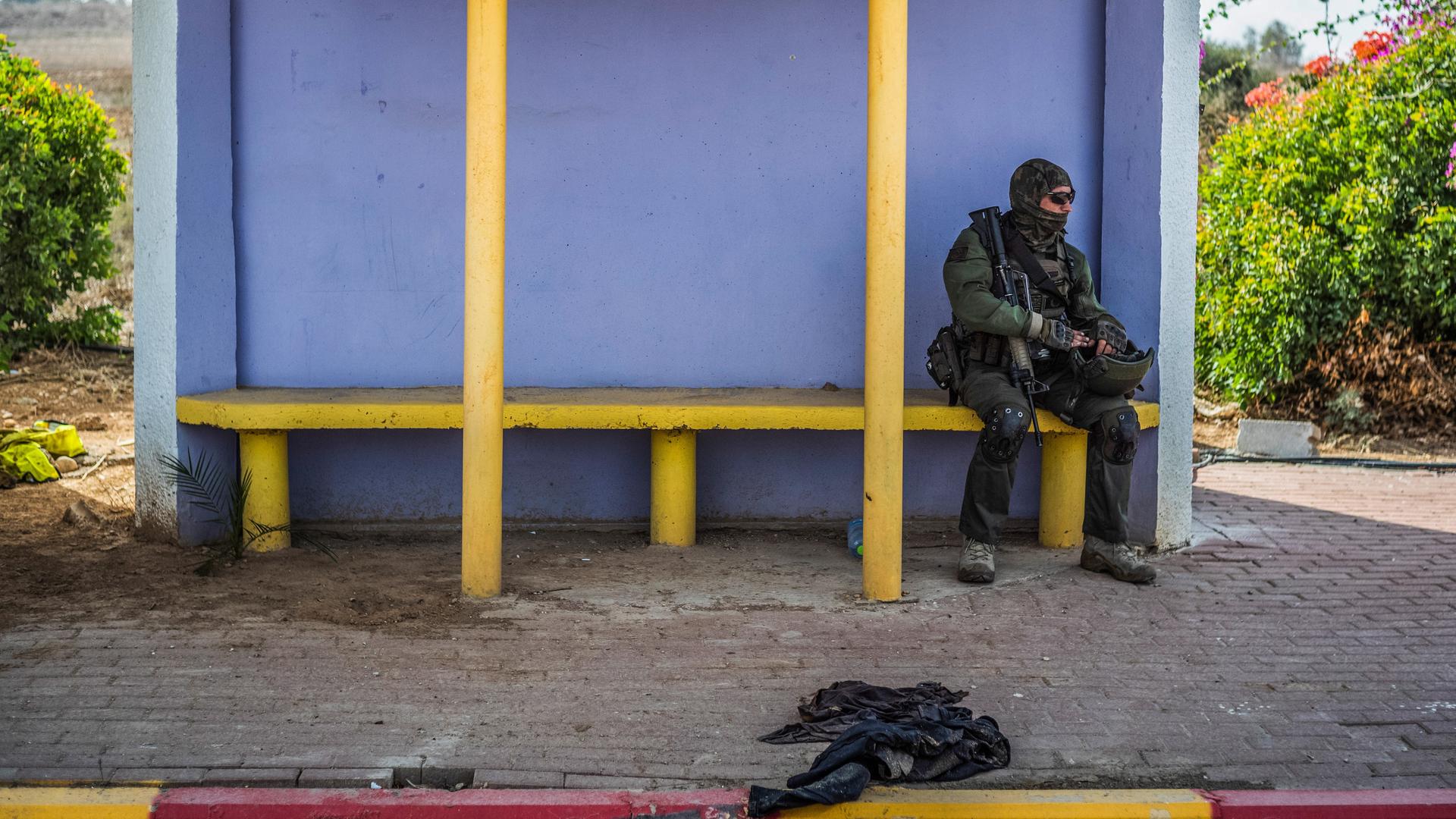 Ein israelischer Soldat sitzt auf einer Bank in einem Wartehaus.