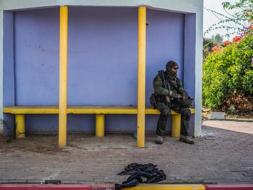 Ein israelischer Soldat sitzt auf einer Bank in einem Wartehaus.