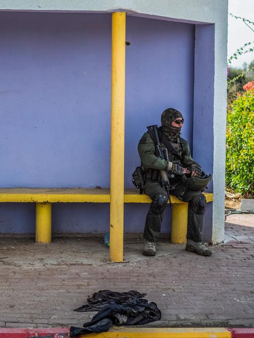 Ein israelischer Soldat sitzt auf einer Bank in einem Wartehaus.