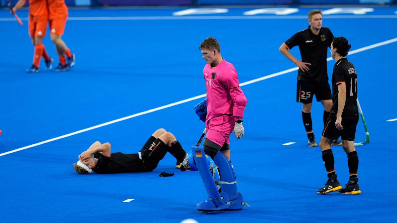 Der deutsche Hockeyspieler Thies Prinz liegt liegt auf dem Boden und hat die Hände vor das Gesicht geschlagen.