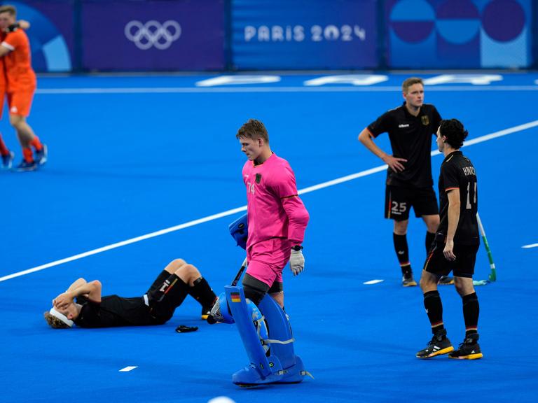 Der deutsche Hockeyspieler Thies Prinz liegt liegt auf dem Boden und hat die Hände vor das Gesicht geschlagen.