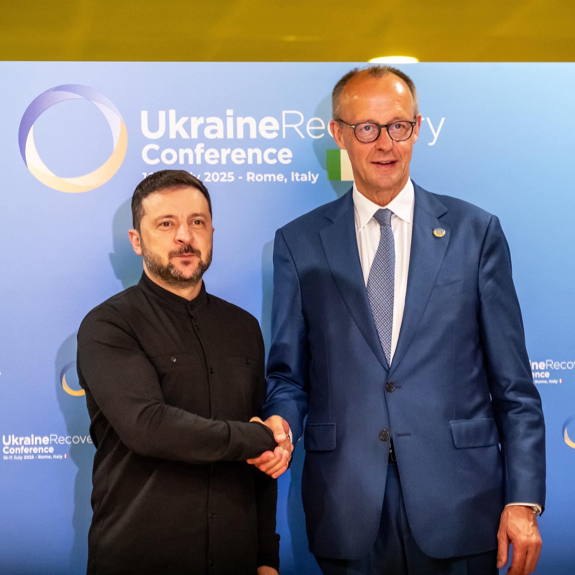 Bundeskanzler Friedrich Merz (CDU, r) und Wolodymyr Selenskyj, Präsident der Ukraine, geben sich bei der Wiederaufbaukonferenz für die Ukraine die Hand, Bundeskanzler Friedrich Merz (CDU, r) und Wolodymyr Selenskyj, Präsident der Ukraine, geben sich bei der Wiederaufbaukonferenz für die Ukraine die Hand,