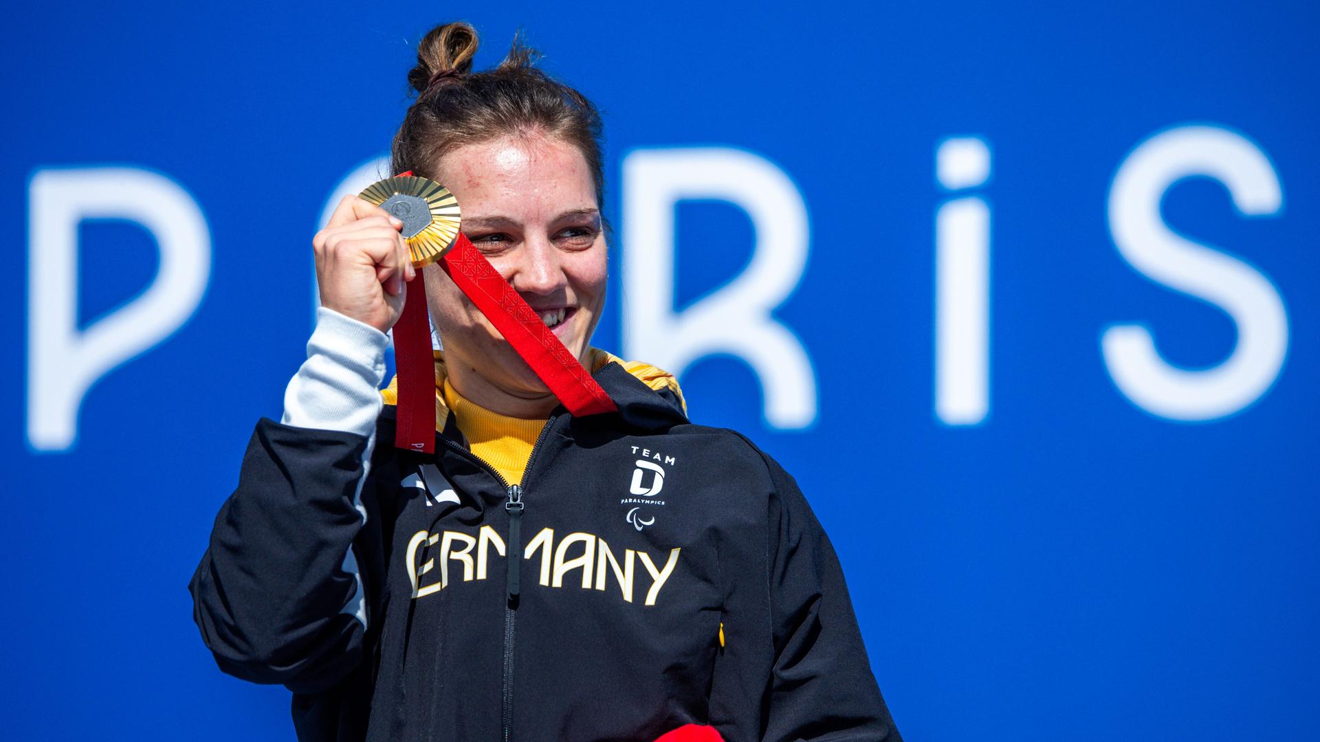 Maike Hausberger hält ihre Goldmedaille in der rechten Hand und lächelt. Maike Hausberger hält ihre Goldmedaille in der rechten Hand und lächelt.