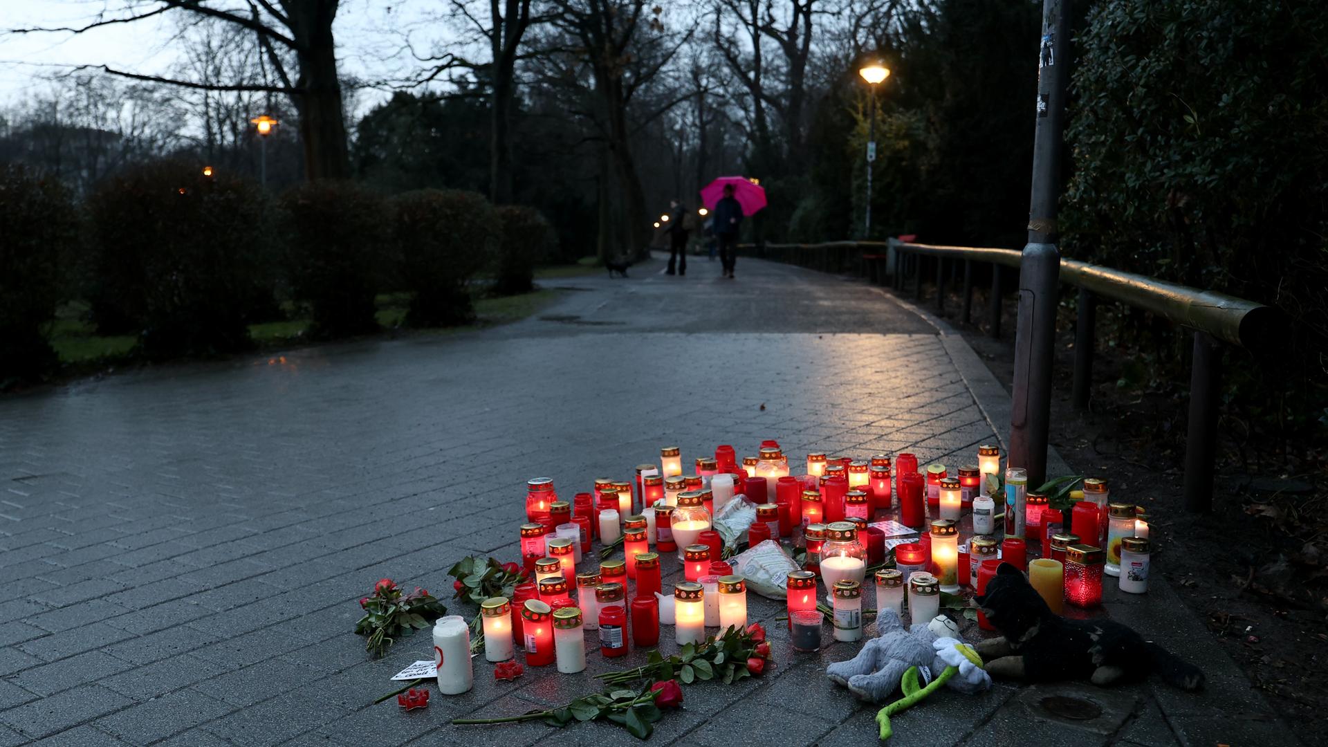 Trauerkerzen, Blumen und Kuscheltiere liegen nach dem tödlichen Messerangriff in Aschaffenburg vom 22.10.2025 in einem Park. Am Tag zuvor war ein zweijähriger Junge und ein 41-jähriger Mann getötet sowie weitere Menschen schwer verletzt worden.