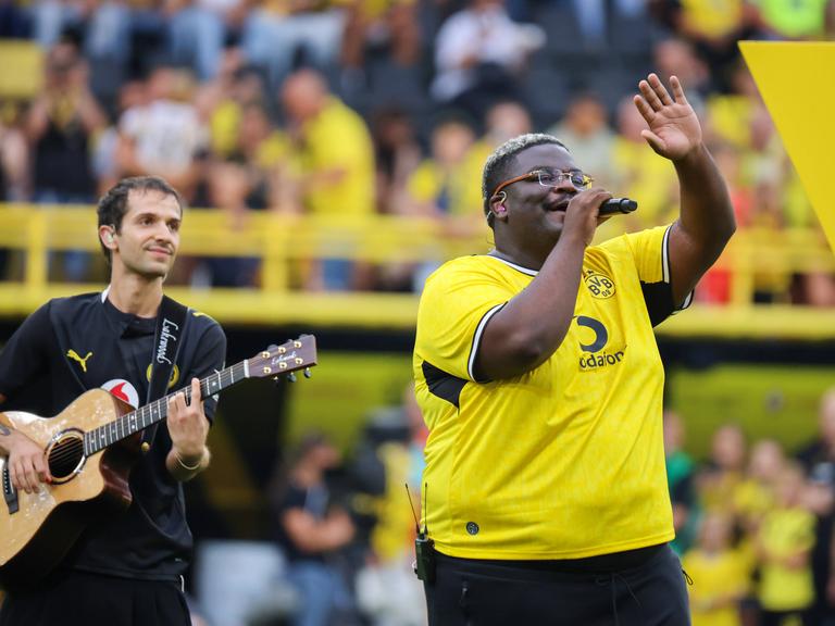 Der Sänger Rayan Djima von der Band Blumengarten singt bei der Saisoneröffnung von Borussia Dortmund den Sommerhit "Du bist gut genug"