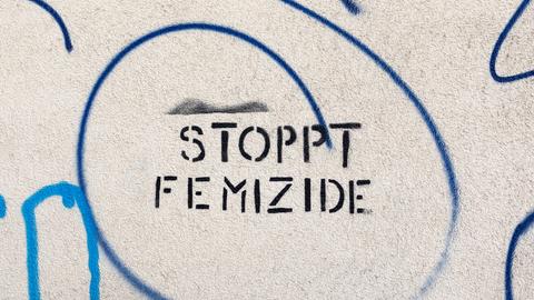 Ein Graffiti auf einer alten Hauswand "Stoppt Femizide"