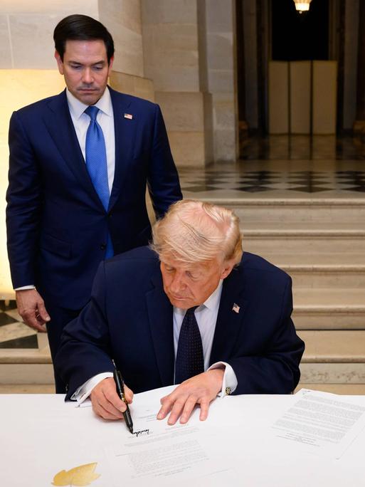 Das Foto zeigt, wie US-Präsident Trump im Schloss von Versailles das Rahmenabkommen mit dem Iran unterzeichnet. Das Foto zeigt, wie US-Präsident Trump im Schloss von Versailles das Rahmenabkommen mit dem Iran unterzeichnet.