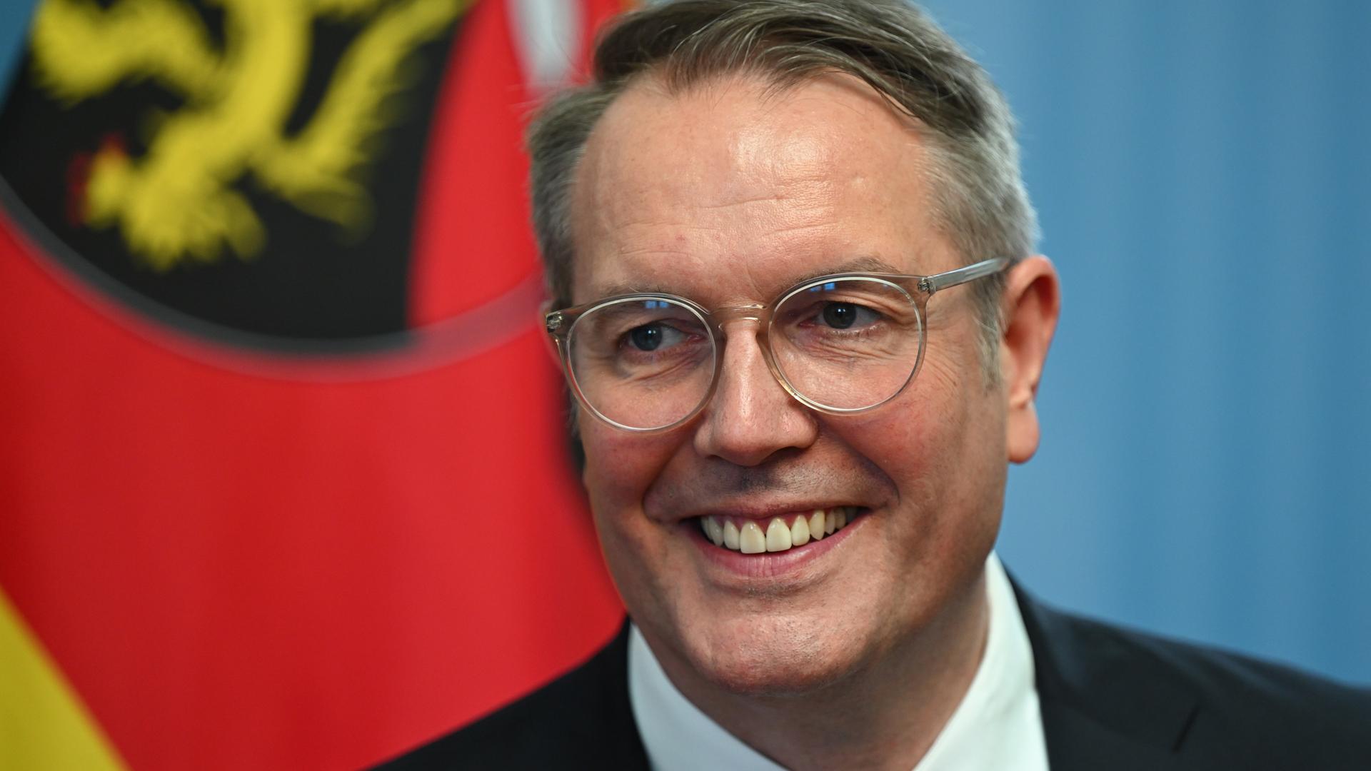 Der neue rheinland-pfälzische Ministerpräsident Alexander Schweitzer (SPD) steht vor der Flagge von Rheinland-Pfalz.