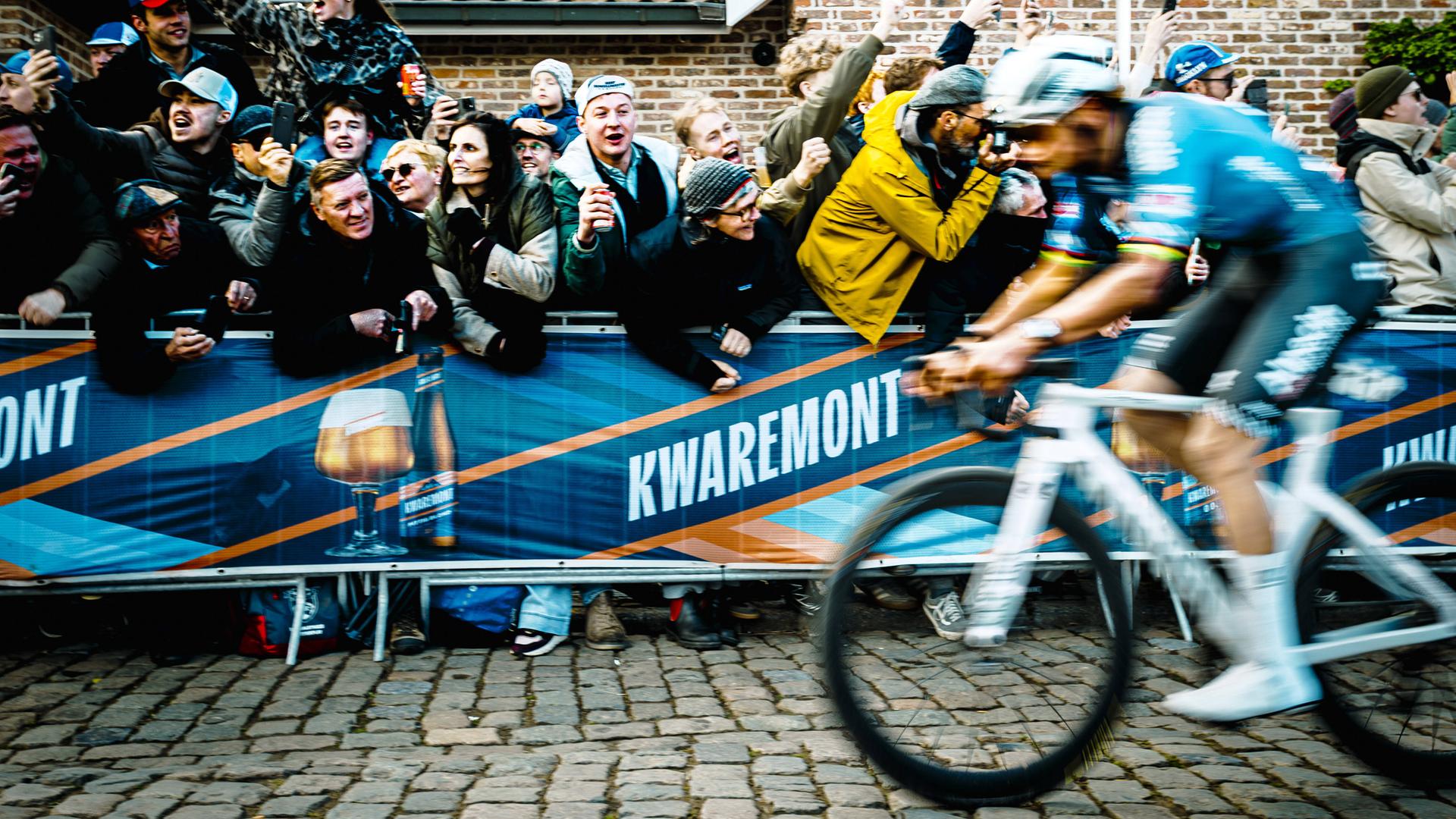 Ein begeistertes Publikum jubelt einem vorbeifahrenden Rennradfahrer zu.