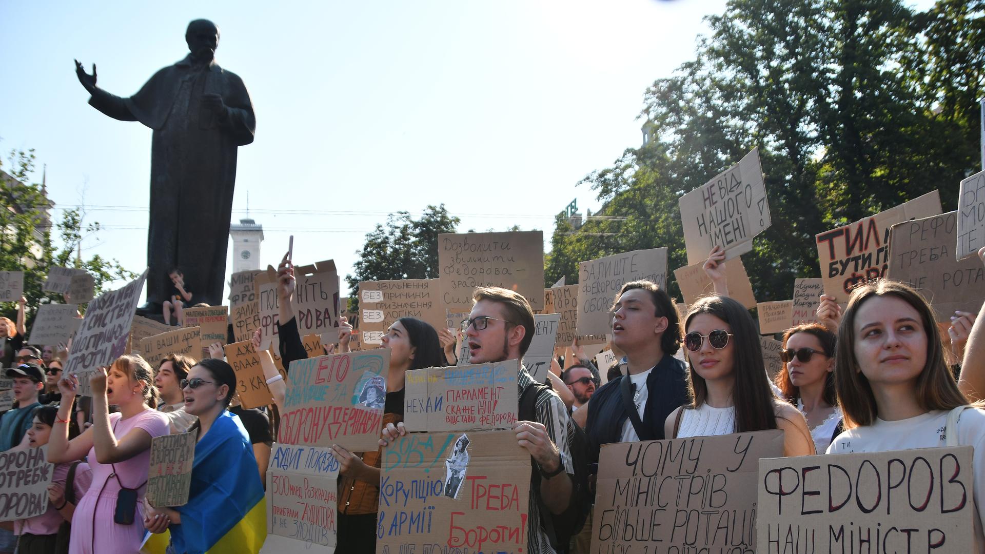 Menschen versammeln sich zu Protesten in der Ukraine. Sie halten Schilder hoch. Menschen versammeln sich zu Protesten in der Ukraine. Sie halten Schilder hoch.