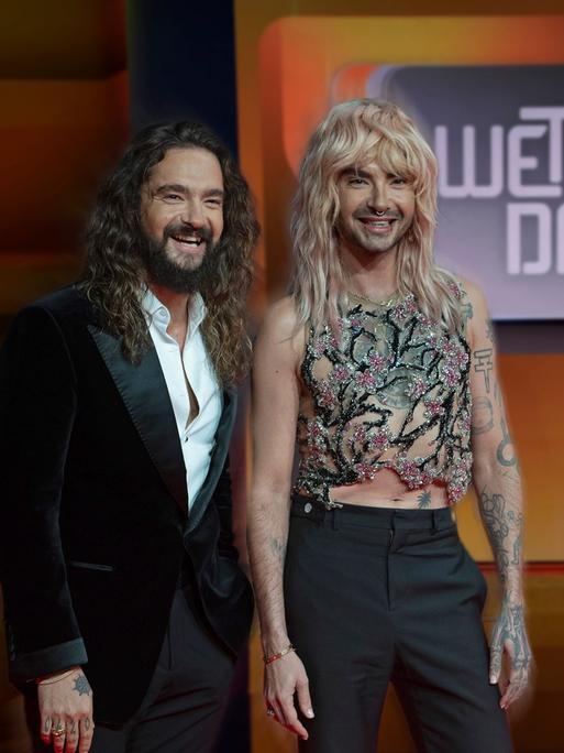 Bill und Tom Kaulitz stehen vor einem Logo von "Wetten, dass..?".