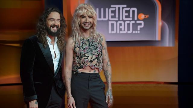 Bill und Tom Kaulitz stehen vor einem Logo von "Wetten, dass..?".