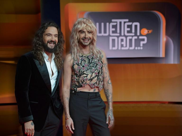 Bill und Tom Kaulitz stehen vor einem Logo von "Wetten, dass..?".