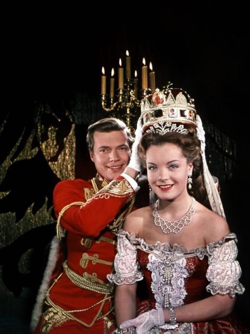 Karlheinz Böhm und Romy Schneider lachen in Kostümierung als Kaiser Franz und Kaiserin "Sissi" Elisabeth in die Kamera.