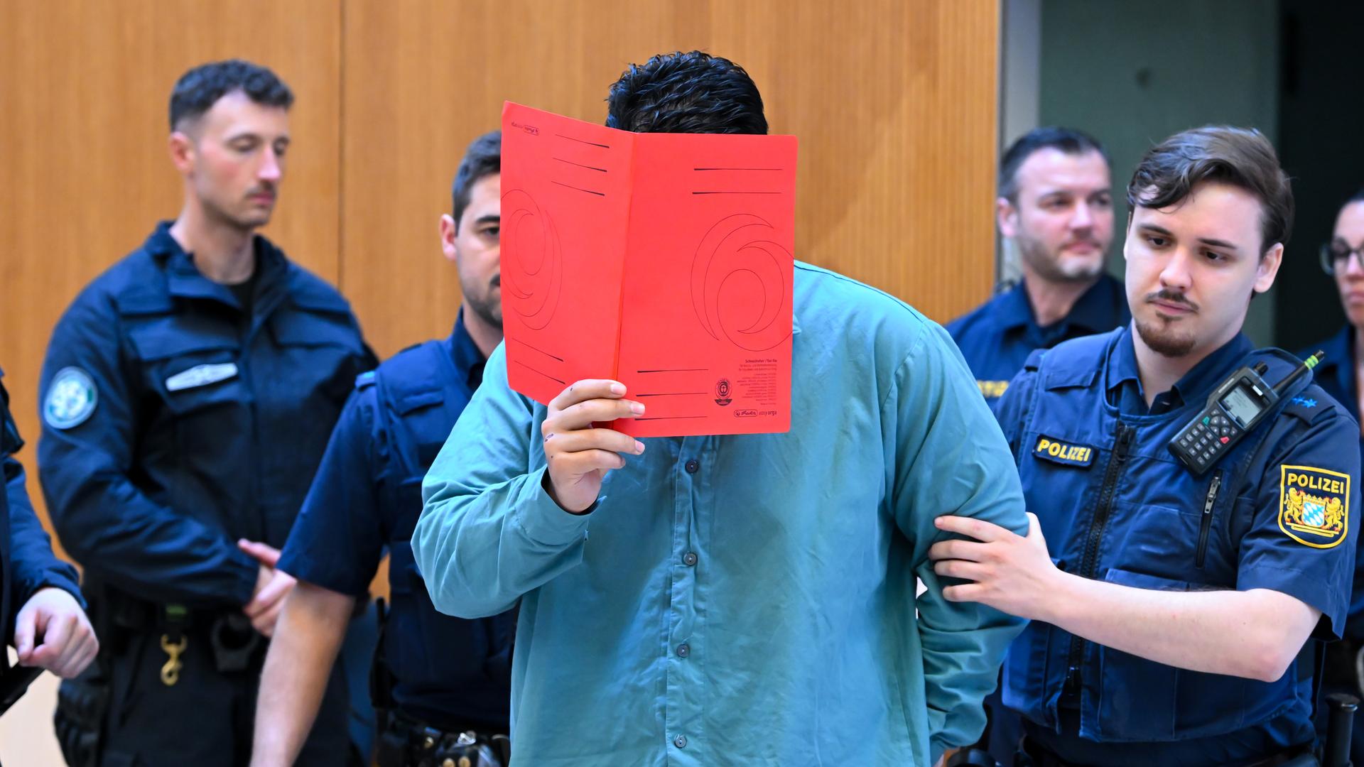 München: Der Angeklagte Farhad N. wird zu Prozessbeginn von Polizeibeamten in den Prozesssaal geführt. München: Der Angeklagte Farhad N. wird zu Prozessbeginn von Polizeibeamten in den Prozesssaal geführt.
