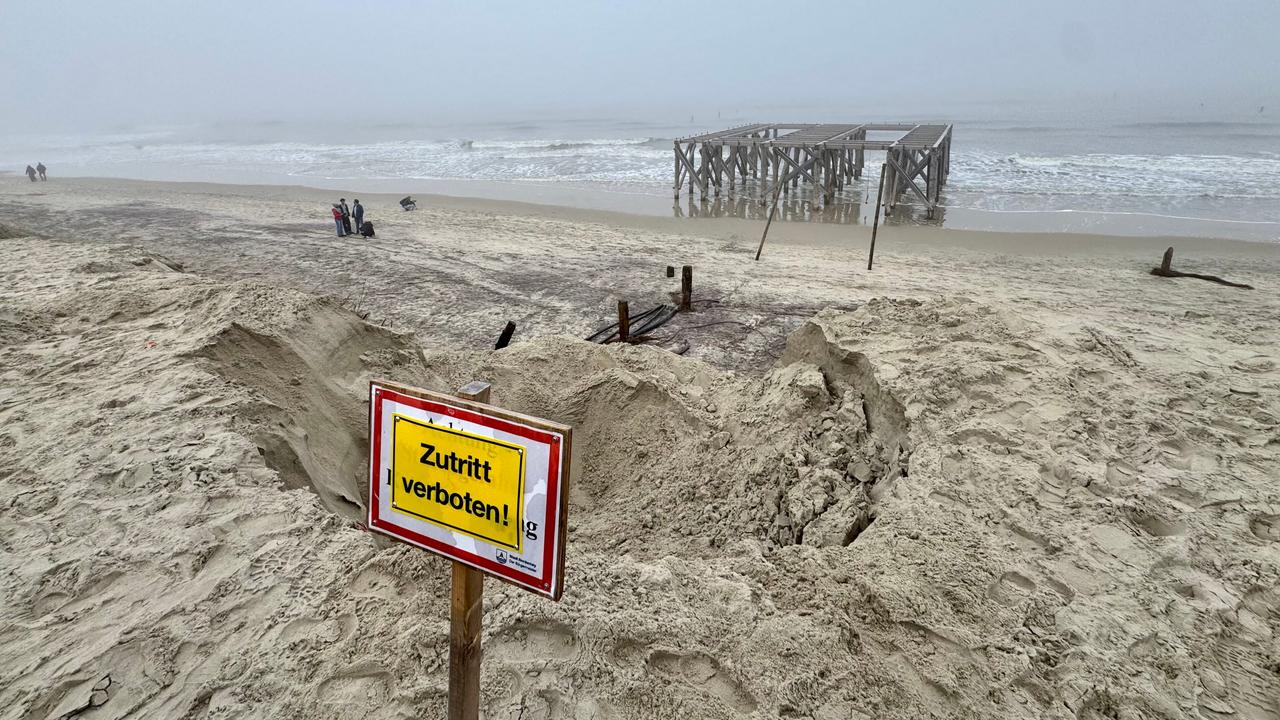 Norderney: Spaziergänger laufen am Strandabschnitt "Weisse Düne" hinter einem "Zutritt verboten" Schild.