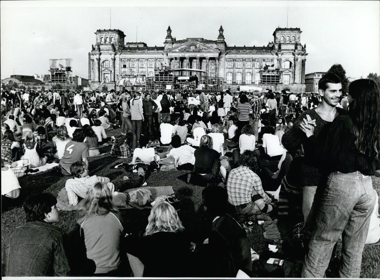 Eine Menschenmenge steht 1980 vor der Bühne vor dem Reichstag in Berlin bei einem Konzert von Barclay James Harvest